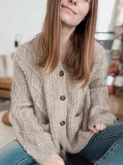 Вязаный спицами кардиган с косами и карманами