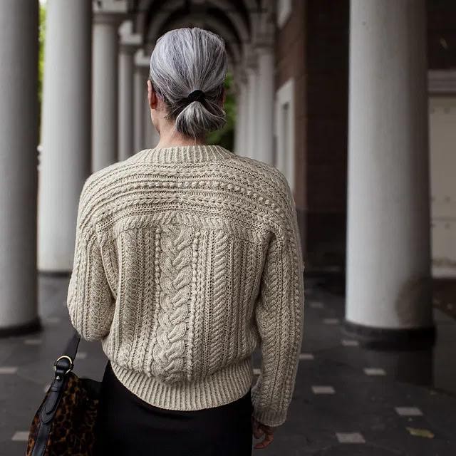 Вязаный спицами пуловер с косами