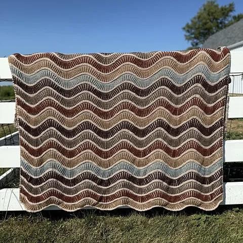 Вязаный спицами плед двухцветной бриошью