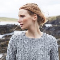 Женский пуловер спицами узором с изящными косами