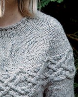 вязаный спицами пуловер с арановыми узорами